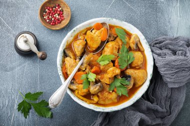 Gulaş geleneksel Macar yemeği. Vintage seramik plaka koyu mavi taş veya beton arka plan üzerinde biber ve domates soslu güveç. Seçici odak. Üstten Görünüm.