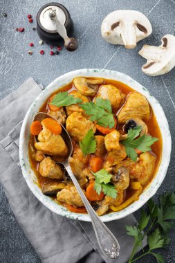 Gulaş geleneksel Macar yemeği. Biber ve domates sosu karanlık sinüs taş veya beton arka plan vintage seramik plaka ile güveç. Seçici odak. Üstten Görünüm.