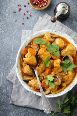 Gulaş geleneksel Macar yemeği. Biber ve domates sosu karanlık sinüs taş veya beton arka plan vintage seramik plaka ile güveç. Seçici odak. Üstten Görünüm.