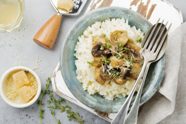 Risotto ile tavuk ve mantar, kekik, sarımsak, eski gri beton zemin üzerine parmesan peyniri. Geleneksel İtalyan yemeği. Seçici odak. Rustik tarzı. Üstten Görünüm.