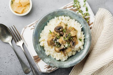 Risotto ile tavuk ve mantar, kekik, sarımsak, eski gri beton zemin üzerine parmesan peyniri. Geleneksel İtalyan yemeği. Seçici odak. Rustik tarzı. Üstten Görünüm.