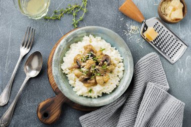 Risotto ile tavuk ve mantar, kekik, sarımsak, eski gri beton zemin üzerine parmesan peyniri. Geleneksel İtalyan yemeği. Seçici odak. Rustik tarzı. Üstten Görünüm.