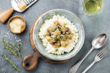 Risotto ile tavuk ve mantar, kekik, sarımsak, eski gri beton zemin üzerine parmesan peyniri. Geleneksel İtalyan yemeği. Seçici odak. Rustik tarzı. Üstten Görünüm.