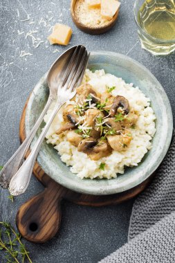 Risotto ile tavuk ve mantar, kekik, sarımsak, eski gri beton zemin üzerine parmesan peyniri. Geleneksel İtalyan yemeği. Seçici odak. Rustik tarzı. Üstten Görünüm.