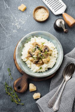 Risotto ile tavuk ve mantar, kekik, sarımsak, eski gri beton zemin üzerine parmesan peyniri. Geleneksel İtalyan yemeği. Seçici odak. Rustik tarzı. Üstten Görünüm.