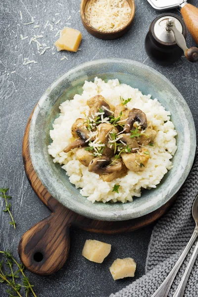 Risotto ile tavuk ve mantar, kekik, sarımsak, eski gri beton zemin üzerine parmesan peyniri. Geleneksel İtalyan yemeği. Seçici odak. Rustik tarzı. Üstten Görünüm.