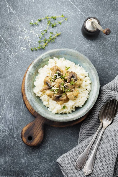 Risotto ile tavuk ve mantar, kekik, sarımsak, eski gri beton zemin üzerine parmesan peyniri. Geleneksel İtalyan yemeği. Seçici odak. Rustik tarzı. Üstten Görünüm.