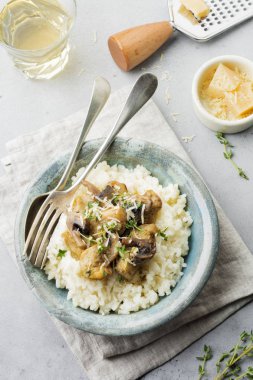 Risotto ile tavuk ve mantar, kekik, sarımsak, eski gri beton zemin üzerine parmesan peyniri. Geleneksel İtalyan yemeği. Seçici odak. Rustik tarzı. Üstten Görünüm.