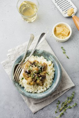 Risotto ile tavuk ve mantar, kekik, sarımsak, eski gri beton zemin üzerine parmesan peyniri. Geleneksel İtalyan yemeği. Seçici odak. Rustik tarzı. Üstten Görünüm.
