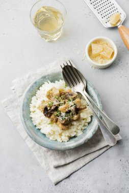 Risotto ile tavuk ve mantar, kekik, sarımsak, eski gri beton zemin üzerine parmesan peyniri. Geleneksel İtalyan yemeği. Seçici odak. Rustik tarzı. Üstten Görünüm.
