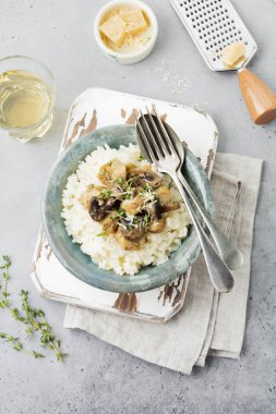 Risotto ile tavuk ve mantar, kekik, sarımsak, eski gri beton zemin üzerine parmesan peyniri. Geleneksel İtalyan yemeği. Seçici odak. Rustik tarzı. Üstten Görünüm.