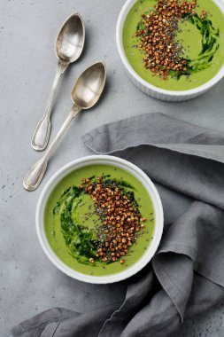 Yararlı smoothies buğday gevreği gri beton tablo arka plan üzerinde seramik kase ıspanak üzerinden. Seçici odak. Üstten Görünüm. Kopya alanı.