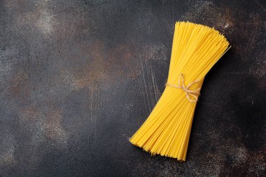 Geleneksel İtalyan makarna spagetti eski karanlık taş zemin üzerine. Gıda arka plan. Seçici odak. Üstten Görünüm.