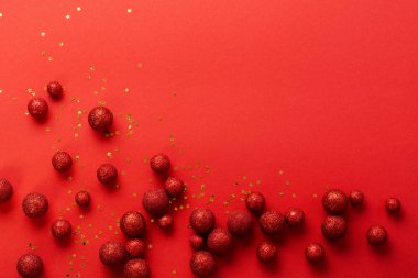 Noel arkaplanı köknar ağacıyla yatıyordu, kırmızı oyuncak toplarından yapılmış Noel ağacı kırmızı arka planda kırmızı zarf içinde altın konfeti süslemişti. Yeni yıl konsepti. Üst görünüm.