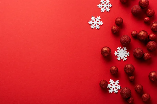 Noel arkaplanı köknar ağacıyla yatıyordu, kırmızı oyuncak toplarından yapılmış Noel ağacı kırmızı arka planda kırmızı zarf içinde altın konfeti süslemişti. Yeni yıl konsepti. Üst görünüm.