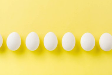 Beyaz çiğ tavuk yumurtası açık beton arka plan üzerinde yatıyor. Üstte görüntü.