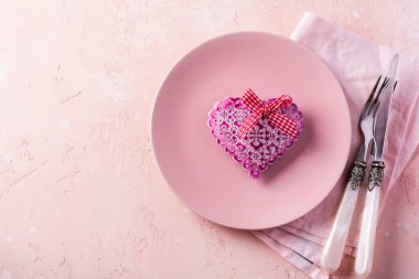 Sevgililer günü masası, pembe tabak ve pembe ışık arka planında hediye kalp..
