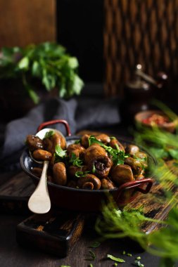 Soya sosunda kızartılmış mantar şampiyonu, biberli ve eski bir masada eski bir metal kasede buğulanmış soğan. Seçici odak.