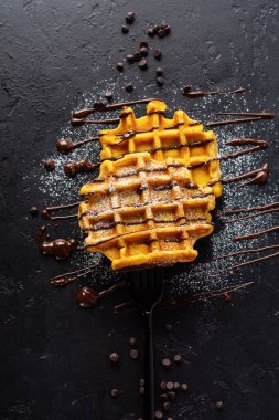 Eskimiş arka planda çikolata ve şeker tozlu balkabağı waffle 'ları. Üst görünüm