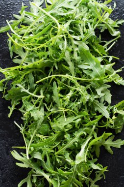 Siyah arka planda taze taze roka yaprakları. Kopyalama alanı olan üst görünüm.