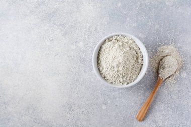 Eski gri beton arka planda seramik bir kasede kapalı bir kolajen. Kopyalama alanı olan düz.