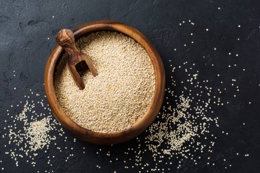 Beyaz kinoa taneleri siyah bir arka planda bambu kasesinde tohumlar. Kopyalama alanı olan düz.