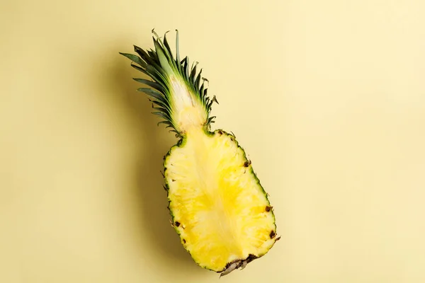 Fresh pineapple cut in two part and paper frame on yellow background. Summer concept. Creative flat lay with copy space. Top view.