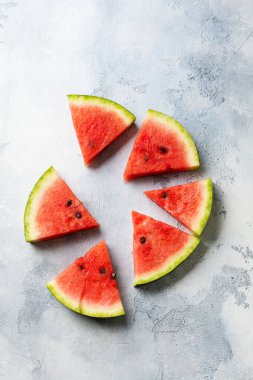 Mavi beton arka planda buzlu taze karpuz dilimleri. Detoks ve vejetaryen konsepti. Üst görünüm, kopyalama alanı, afiş