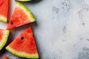 Mavi beton arka planda buzlu taze karpuz dilimleri. Detoks ve vejetaryen konsepti. Üst görünüm, kopyalama alanı, afiş