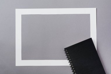 Klasik mavi arkaplan üzerine defter, eskiz defteri ve kağıt çerçeve. Sabah minimum konsepti. Kopyalama alanı olan üst görünüm.