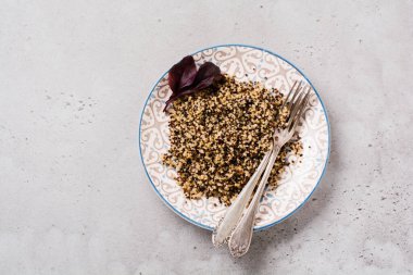 Eski karanlık arka planda seramik tabakta sunulan sağlıklı yemek için kinoa. Üst görünüm.