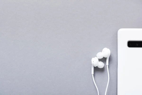Moderne Weiße Kopfhörer Und Mobiltelefone Auf Grauem Hintergrund Minimalistischer Stil — Stockfoto