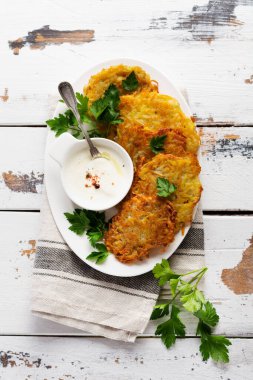 Draniki - patates kızartması, vejetaryen patatesli gözleme, taze otlar ve sarımsaklı yoğurt sosu ile servis edilmiş,.