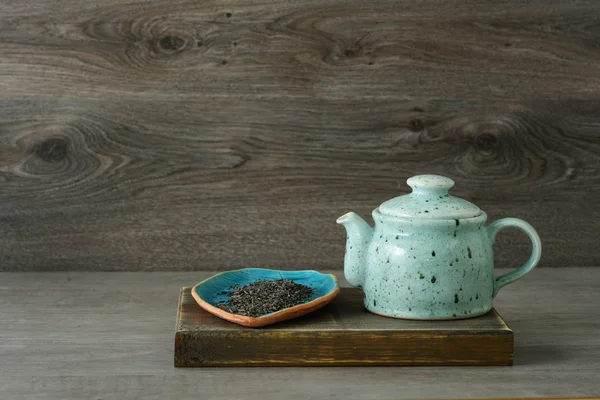 Théière en céramique bleue avec thé sur un fond en bois — Photo
