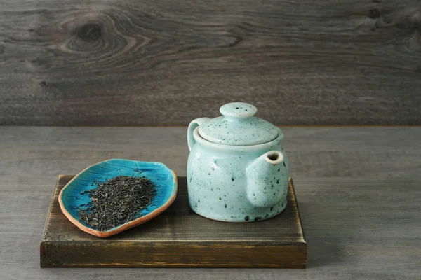 Bule de cerâmica azul com chá em um fundo de madeira — Fotografia de Stock
