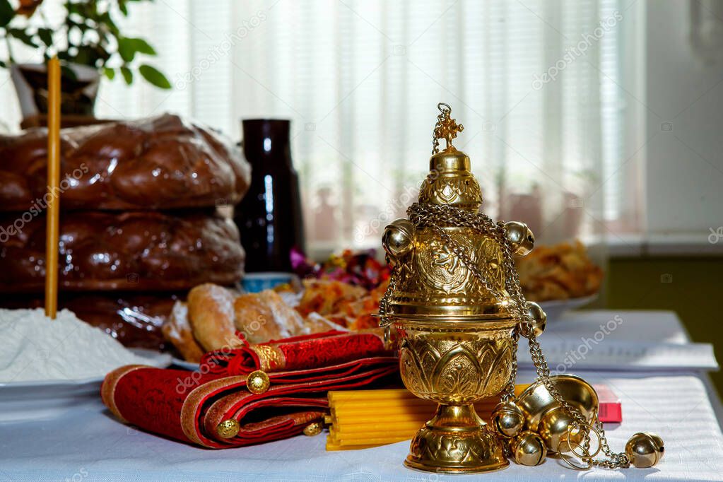 wicker bread, censer, candles, sweets, treats are on the table, church supplies