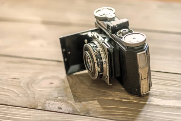 Vinobraní fotoaparát na dřevěný stůl — Stock fotografie