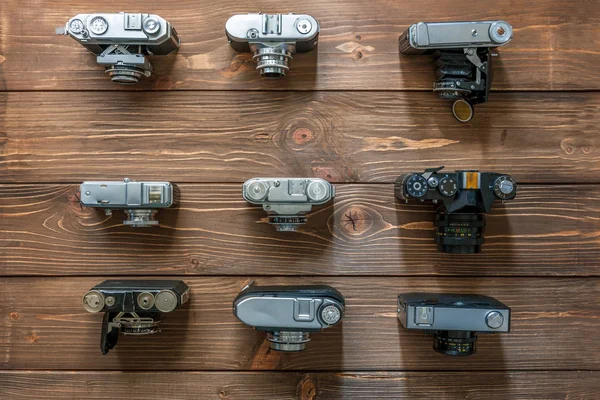 Câmeras vintage e lentes em fundo de madeira — Fotografia de Stock