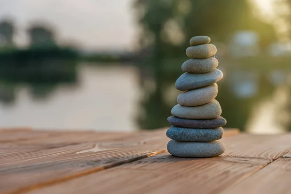 Zen dengeleyici çakıl taşları sisli bir gölün yanında