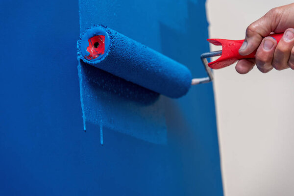 workman painting the wall in blue