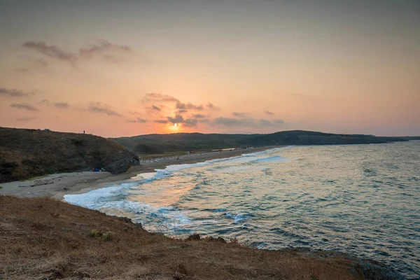 Pantai saat matahari terbenam dengan busa gelombang — Stok Foto