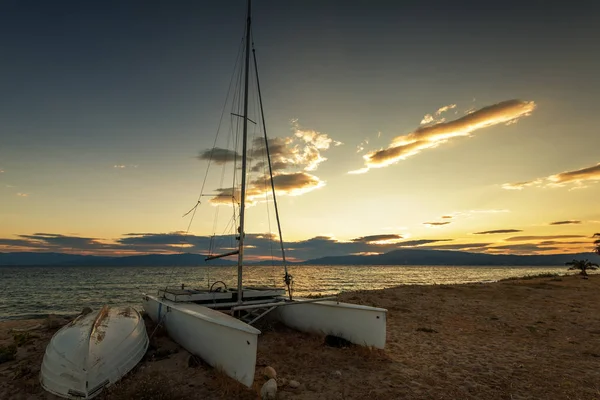 Voilier sur la plage au coucher du soleil . — Photo