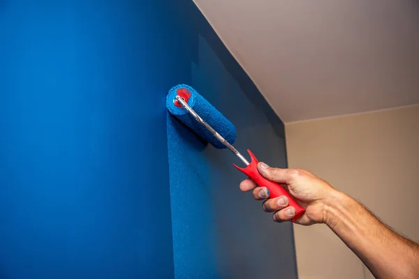Obrero pintando la pared en azul . — Foto de Stock