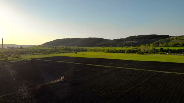 Luftaufnahme Des Sonnenuntergangs Über Dem Traktor Der Das Feld Eggt — Stockvideo