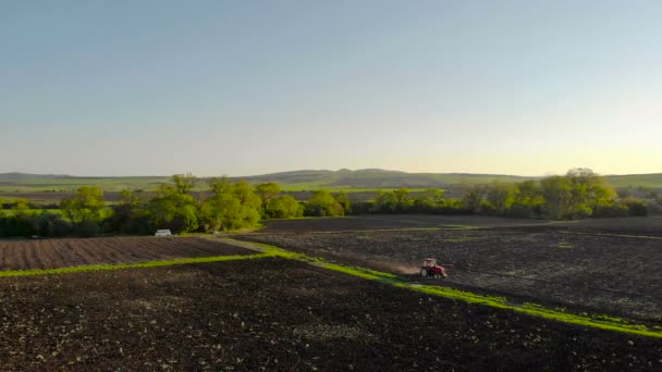 Luftaufnahme Des Sonnenuntergangs Über Dem Traktor Der Das Feld Eggt — Stockvideo