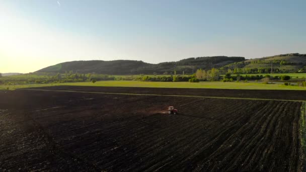 Luftaufnahme Des Sonnenuntergangs Über Dem Traktor Der Das Feld Eggt — Stockvideo