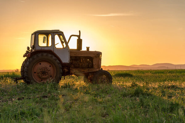 Красный трактор на золотом небе заката
.