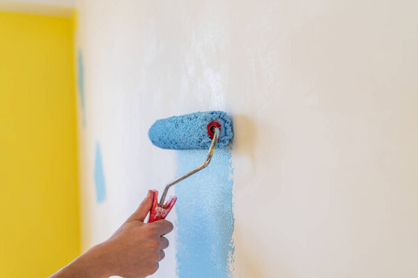 Decorator's hand painting wall with roller.
