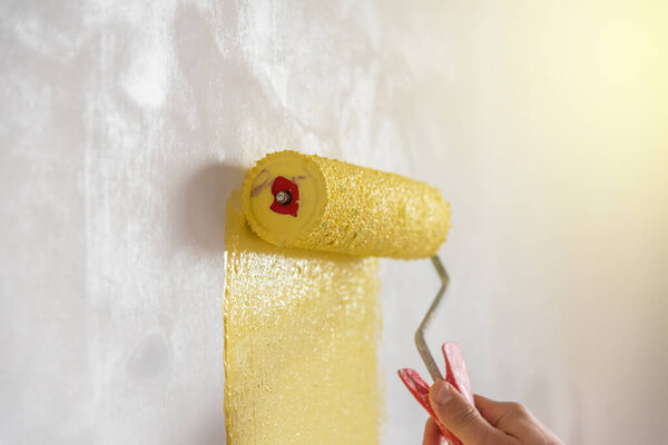 Decorator's hand painting wall with roller.