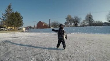 Küçük çocuk oyun hokey. Paten ve bir sopa ile ateş çocuk öğrenir.
